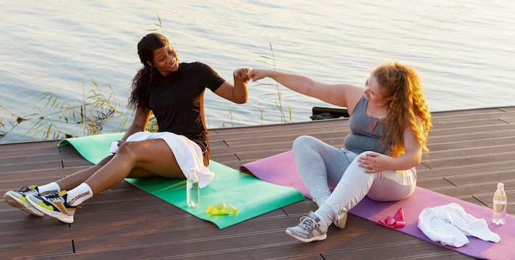 Two women fist-bumping after a workout, smiling happily